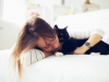 Young girl hugs cat