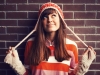 Smiling girl in red against brick wall