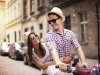 Handsome man taking his girlfriend on bicycle rack