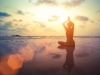 Young woman practicing yoga on the beach