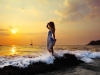 Young woman standing on rock in sea