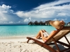 Young woman reading a book at the beach