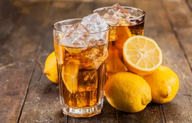 Iced tea with lemon and mint on wooden table