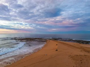 Sunrise Seascape with Calm Seas and a Cloud Covered Sky