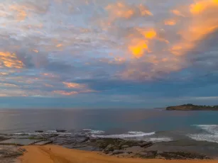 Sunrise Seascape with Calm Seas and a Cloud Covered Sky