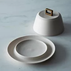 BRONZE HANDLE BUTTER DISH We love the simple, beautiful work of Portland based ceramicist Lisa Jones of Pigeon Toe. This hearty porcelain butter dish is enhanced by a square bronze handle giving it a modern but timeless elegance.
