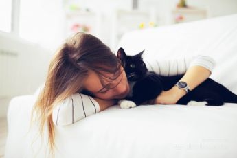 Young girl hugs cat