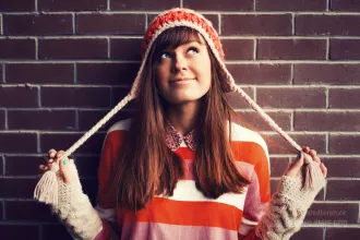 Smiling girl in red against brick wall