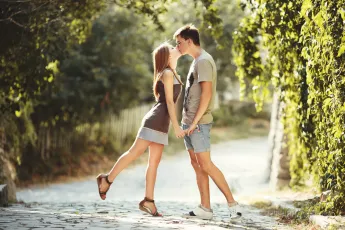 Teen couple kissing at street