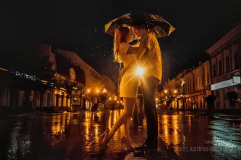 Couple kissing under an umbrella