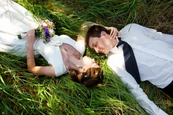 Wedding couple lying in grass