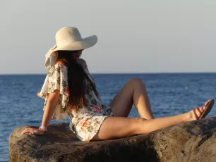 Girl in Hat on Rocks on Santorini