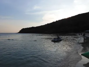 DSCN1040.JPG: Evening calm, a lone jet ski rests near the shore as the sun dips behind the hillside.
