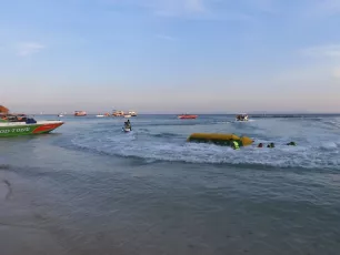 DSCN1041.JPG: Tourists enjoy a sunny afternoon ride as speedboats and a banana boat cut through gentle waves near the shore.