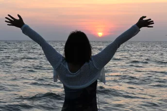 DSC_3520: Arms wide open to the setting sun — embracing the calm of the sea and the promise of a new day.