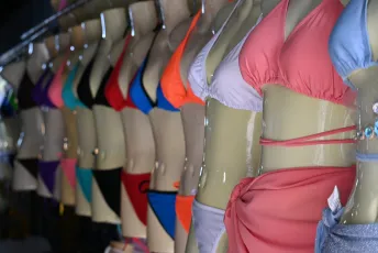 DSC_4499: A row of mannequins dressed in colorful bikinis and swimwear on display.