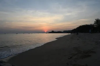 DSC_7767: Sunset paints the horizon as gentle waves lap the quiet shoreline.