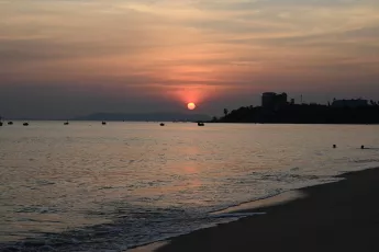 DSC_7766: Golden sun sinking over a tranquil shoreline, painting the sea and sky in soft hues of dusk.