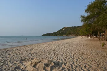 DSC_8703: a sandy beach with people swimming in the water