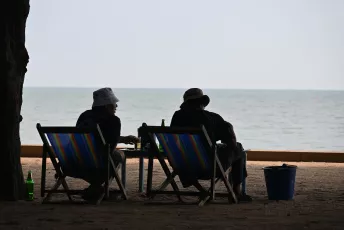 DSC_9591: two people sitting at a table on the beach