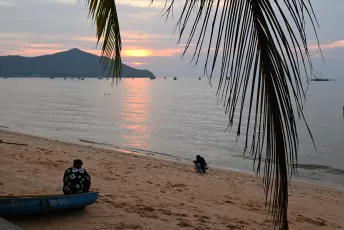 DFC_0008: a couple of people sitting on top of a sandy beach