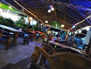 IMG_20191026_181331953: Cozy open-air restaurant glowing with colorful lanterns and string lights, ready for a relaxed evening.