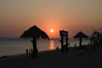 DZ6_2673: Golden hour at the beach - palm-thatched huts, gentle waves, and a sunset that slows time.