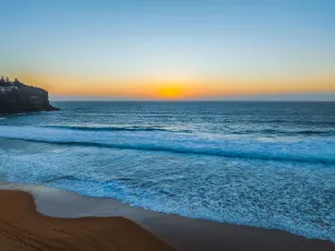Sunrise at the Seaside with a hazy cloudless sky