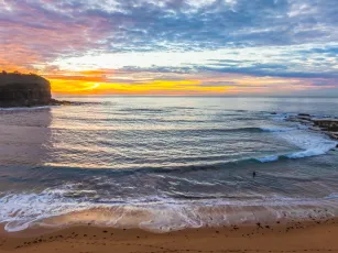 Sunrise Seascape with Calm Seas and a Cloud Covered Sky